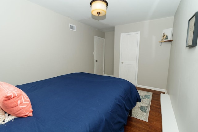 bedroom with wood finished floors and baseboards