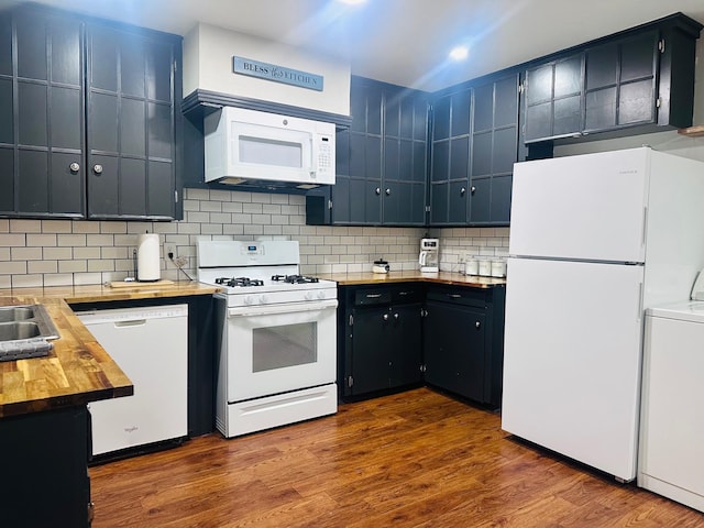 kitchen with white appliances, washer / dryer, wooden counters, tasteful backsplash, and dark wood-type flooring