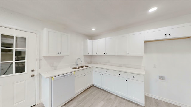 kitchen featuring dishwasher, a sink, light countertops, white cabinets, and light wood-style floors