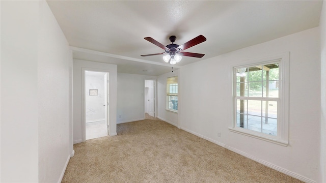 spare room featuring baseboards, a ceiling fan, and carpet