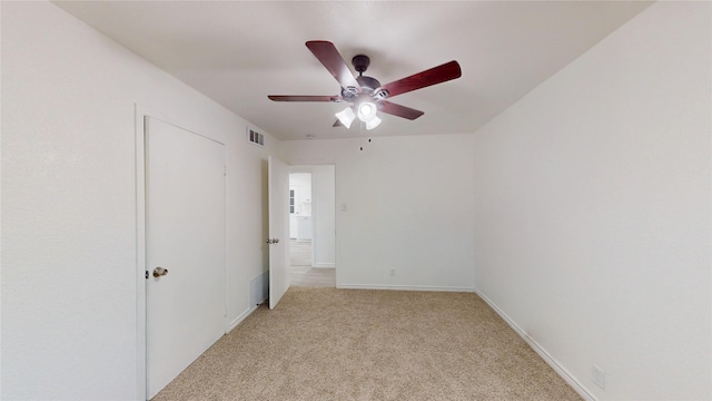 unfurnished bedroom with visible vents, a ceiling fan, baseboards, and light colored carpet