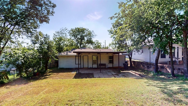 rear view of house with a yard, fence, and a patio area