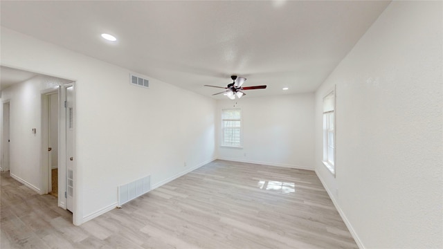 empty room featuring a ceiling fan, baseboards, visible vents, and light wood-type flooring