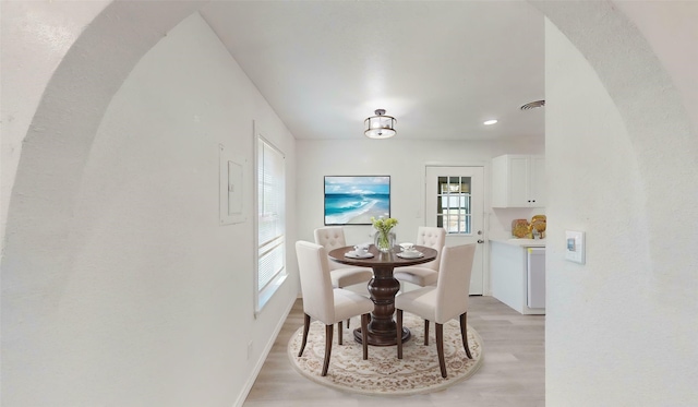 dining area featuring baseboards, visible vents, light wood-type flooring, and a wealth of natural light