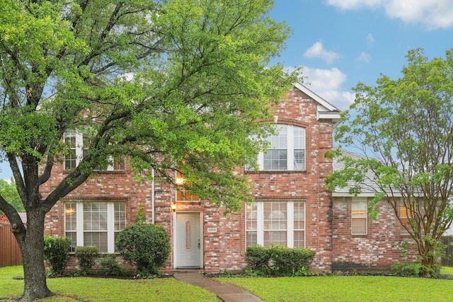 view of front of property featuring a front yard and brick siding