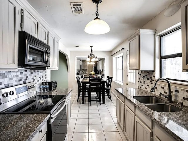 1213 Dennis Dr, Saginaw, TX 76179 - kitchen with electric range, visible vents, black microwave, tasteful backsplash, and a sink