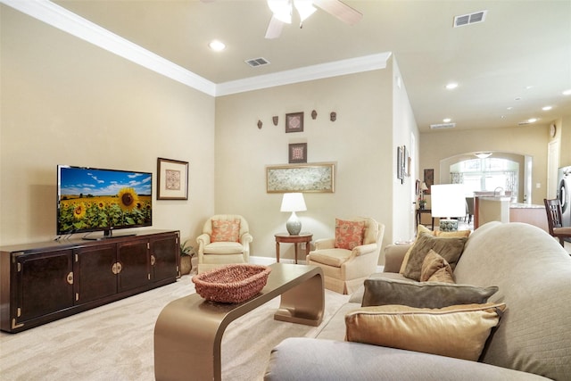 living room with arched walkways, ornamental molding, ceiling fan, light carpet, and recessed lighting
