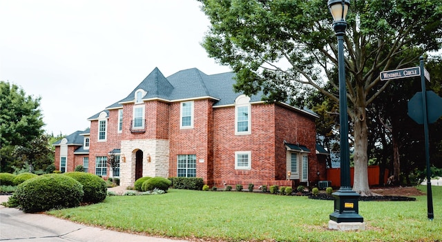 view of front of property featuring a front yard and brick siding