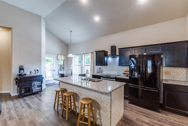 2868 Pacifico Way, Fort Worth, TX 76111 - kitchen featuring black refrigerator with ice dispenser, a sink, wall chimney range hood, electric range, and a breakfast bar