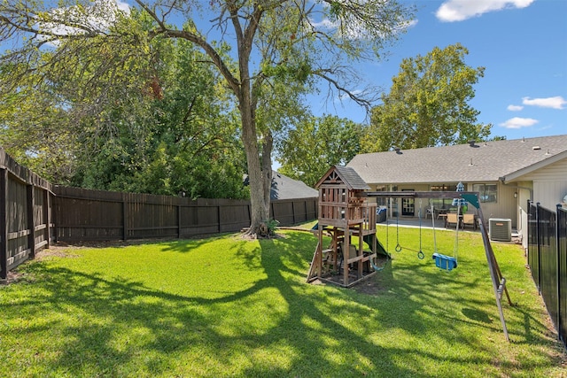 view of yard featuring a playground, central AC unit, and a fenced backyard