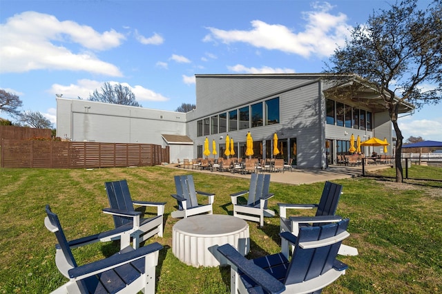 back of house featuring fence, a yard, an outdoor fire pit, and a patio area