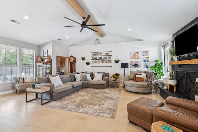 living room with lofted ceiling with beams, a brick fireplace, light wood-style flooring, a ceiling fan, and visible vents