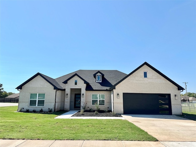 303 Third, Lindsay, TX 76250 - view of front facade with brick siding, a garage, a front yard, and concrete driveway