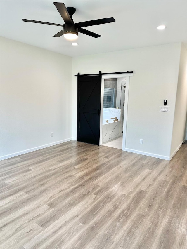 303 Third, Lindsay, TX 76250 - spare room featuring light wood-style floors, baseboards, recessed lighting, a barn door, and a ceiling fan