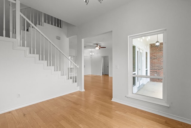 interior space featuring baseboards, light wood-style flooring, and stairway