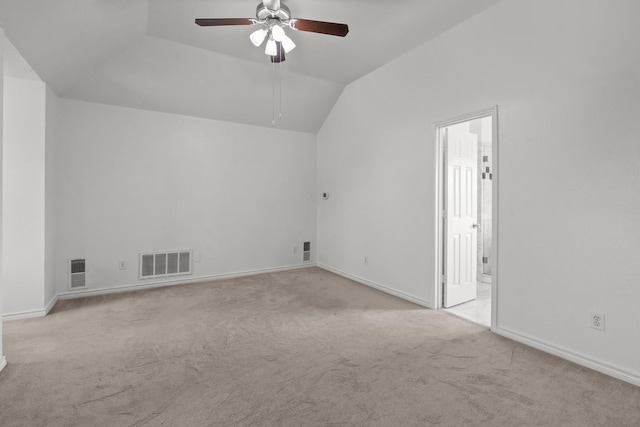 carpeted spare room with a ceiling fan, baseboards, visible vents, and vaulted ceiling