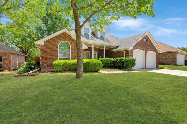 traditional-style house featuring a front lawn, brick siding, a shingled roof, concrete driveway, and an attached garage
