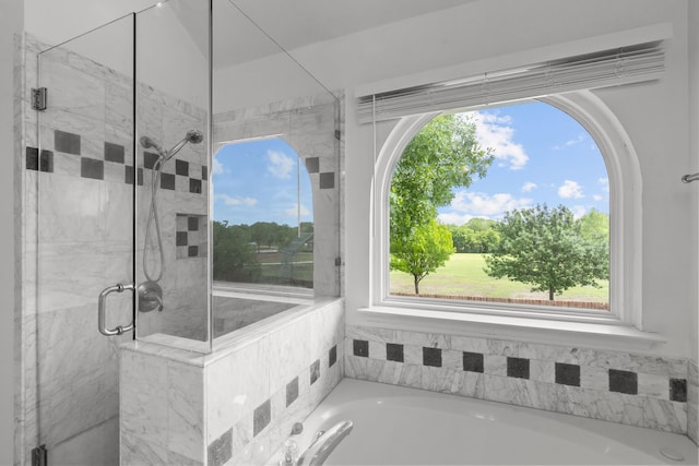full bath with a bath, a wealth of natural light, and a shower stall
