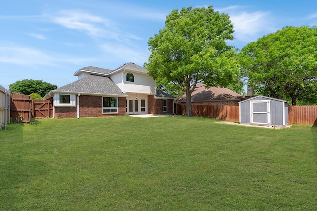 rear view of house featuring a storage shed, brick siding, a fenced backyard, and a lawn