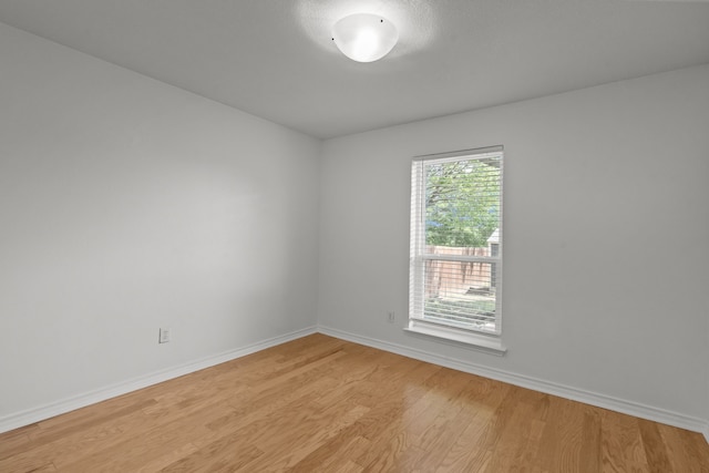 unfurnished room featuring light wood-type flooring and baseboards