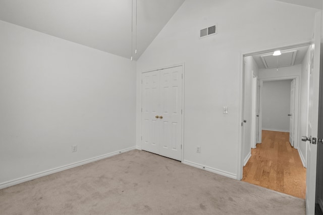 unfurnished bedroom featuring visible vents, attic access, carpet floors, and a closet