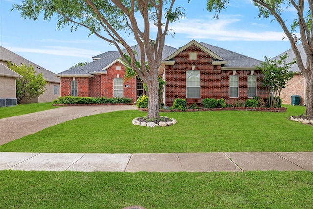 view of front of house with brick siding, roof with shingles, and a front yard