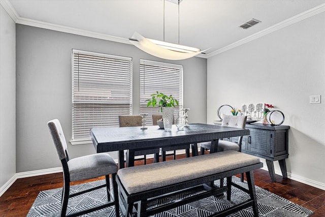 dining room featuring baseboards, ornamental molding, wood finished floors, and visible vents