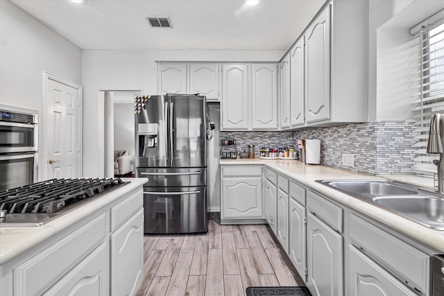 kitchen featuring light countertops, appliances with stainless steel finishes, backsplash, and visible vents