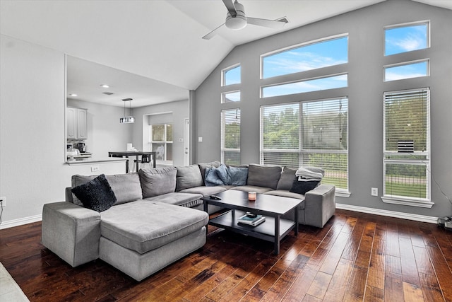 living area with vaulted ceiling, baseboards, a ceiling fan, and dark wood-style flooring