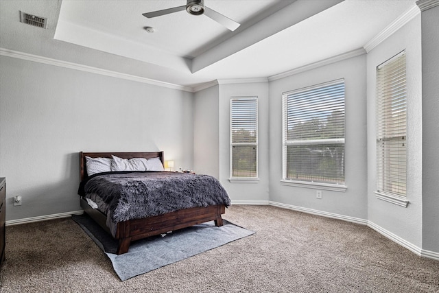 carpeted bedroom featuring ceiling fan, visible vents, ornamental molding, and a raised ceiling