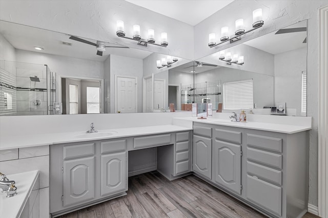 bathroom featuring vanity, visible vents, wood finished floors, and a stall shower