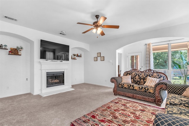 2317 Willard Dr, Mckinney, TX 75072 - living room featuring ceiling fan, arched walkways, carpet flooring, a fireplace with raised hearth, and baseboards