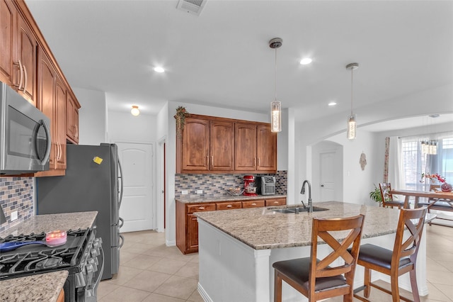 2317 Willard Dr, Mckinney, TX 75072 - kitchen with a sink, stainless steel microwave, arched walkways, range with gas cooktop, and decorative backsplash