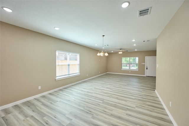 spare room featuring recessed lighting, baseboards, light wood-style flooring, and a chandelier