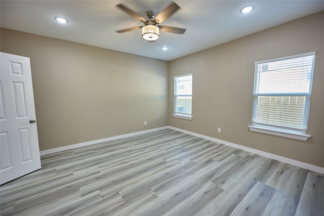 spare room featuring a ceiling fan, baseboards, light wood finished floors, and recessed lighting