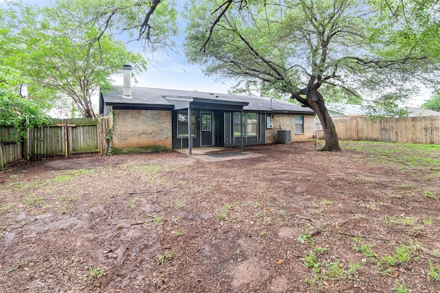 628 Evelyn Ln, Burleson, TX 76028 - back of house with brick siding, a fenced backyard, central AC, and a chimney