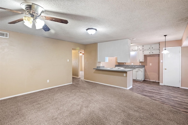 628 Evelyn Ln, Burleson, TX 76028 - kitchen with baseboards, a peninsula, dark carpet, and visible vents
