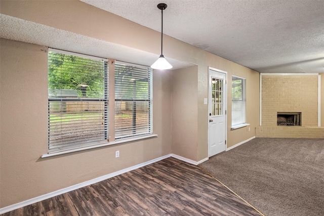 628 Evelyn Ln, Burleson, TX 76028 - interior space featuring a textured ceiling, a fireplace, wood finished floors, baseboards, and a textured wall