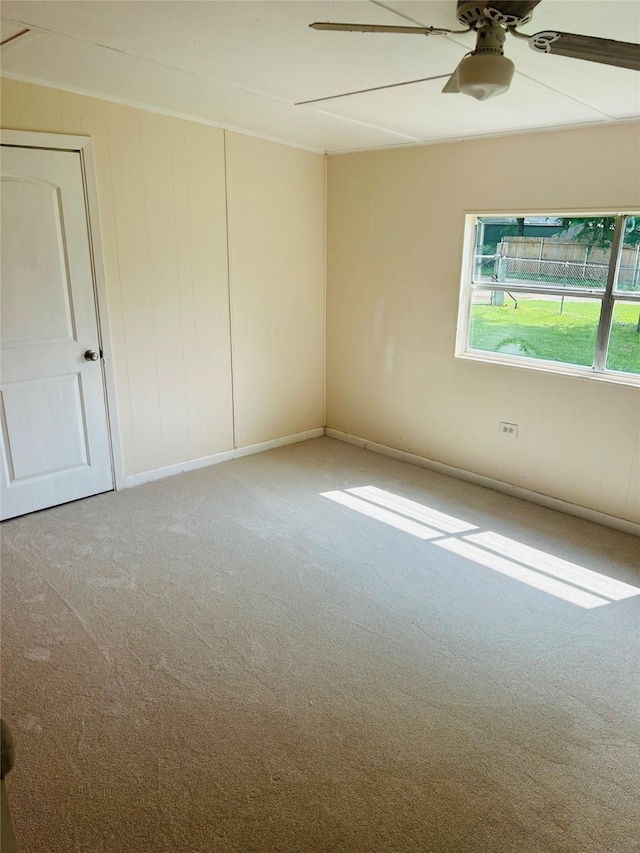 carpeted empty room featuring a ceiling fan