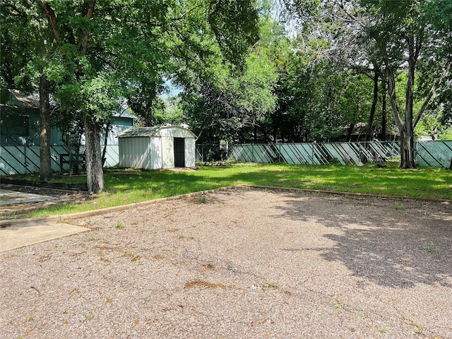 view of yard with fence, a storage unit, and an outdoor structure