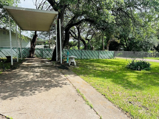 view of yard featuring fence and a carport