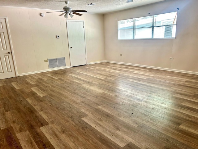 spare room with visible vents, a ceiling fan, a textured ceiling, and wood finished floors