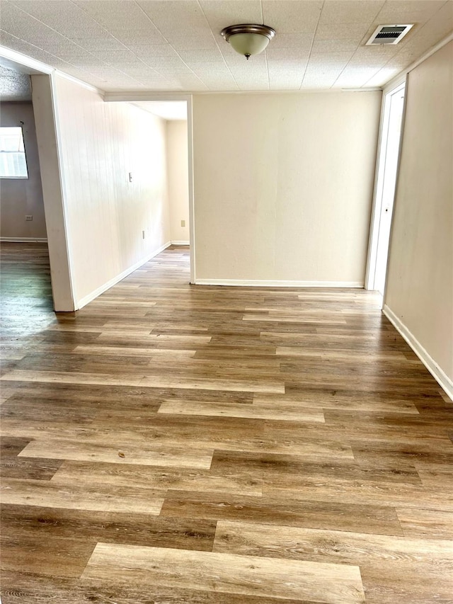 interior space with baseboards, wood finished floors, and visible vents