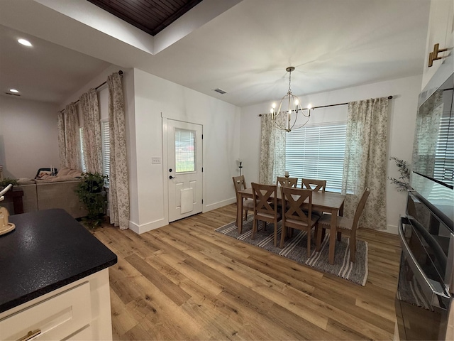 dining space with visible vents, baseboards, recessed lighting, light wood finished floors, and a notable chandelier