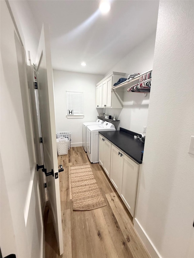laundry room featuring baseboards, recessed lighting, separate washer and dryer, cabinet space, and light wood finished floors
