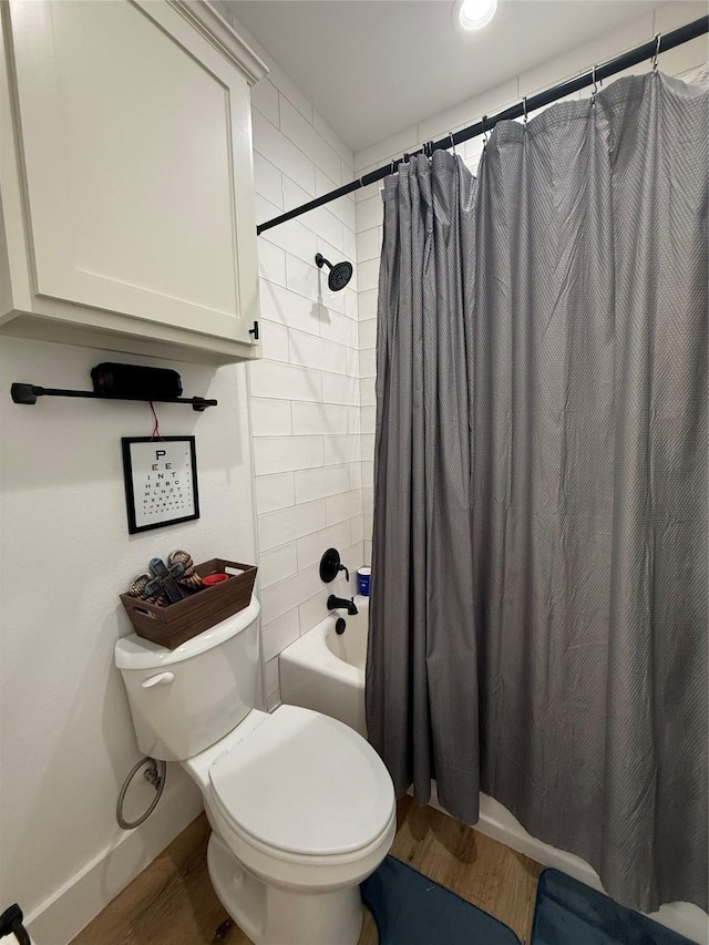 bathroom featuring wood finished floors, toilet, shower / bath combo with shower curtain, recessed lighting, and baseboards
