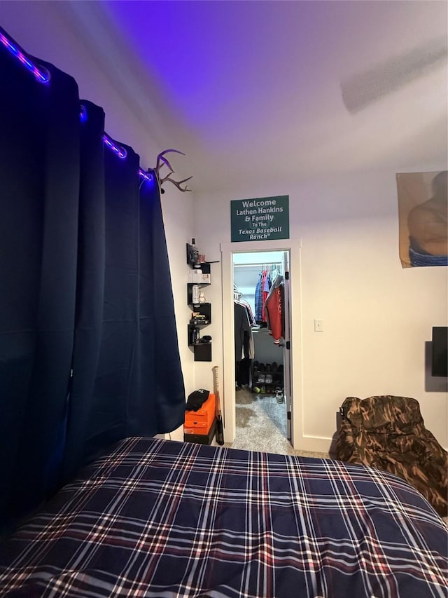 bedroom featuring a walk in closet, carpet, and a closet