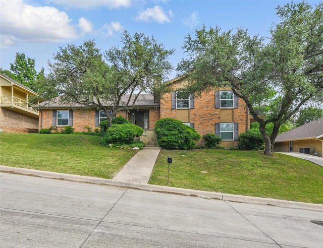split level home featuring brick siding and a front yard