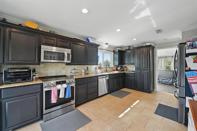 kitchen with ornamental molding, a toaster, a healthy amount of sunlight, and stainless steel appliances