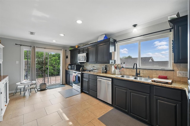 kitchen featuring appliances with stainless steel finishes, a sink, recessed lighting, tasteful backsplash, and ornamental molding
